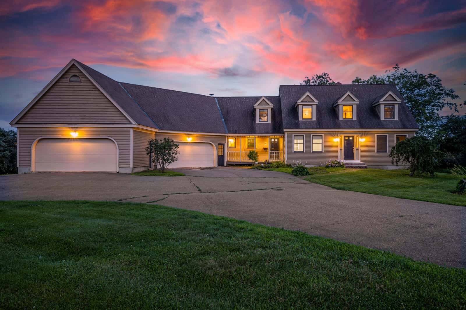 Twilight exterior photo of a home in Portsmouth, New Hampshire, windows glowing at dusk