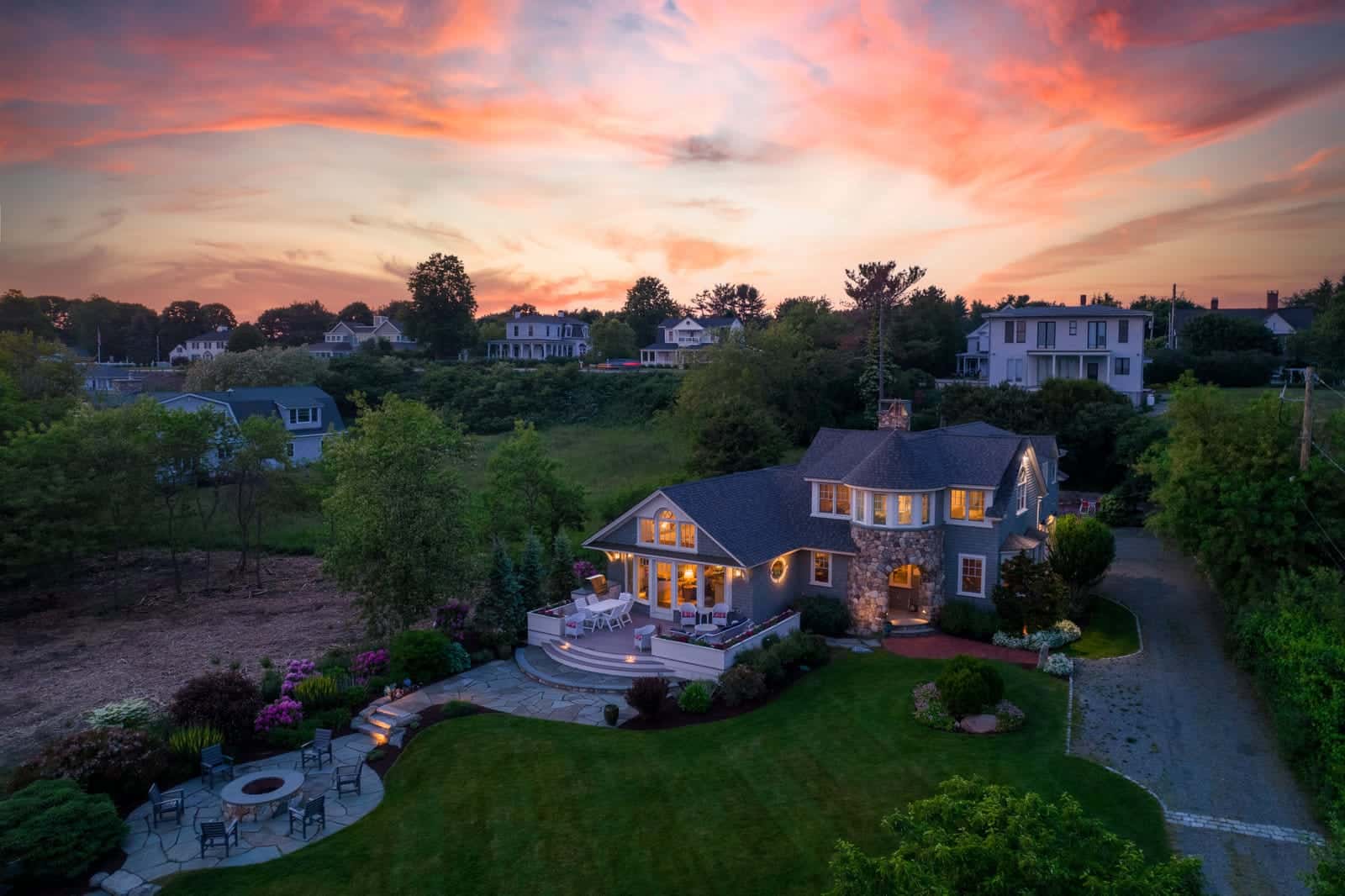 Twilight exterior photo of a home in North Hampton, New Hampshire, windows glowing at dusk