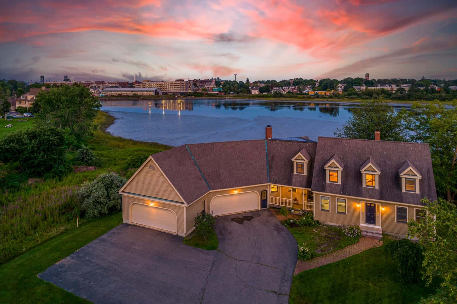 Twilight exterior photo of a home in Portsmouth, New Hampshire, windows glowing at dusk