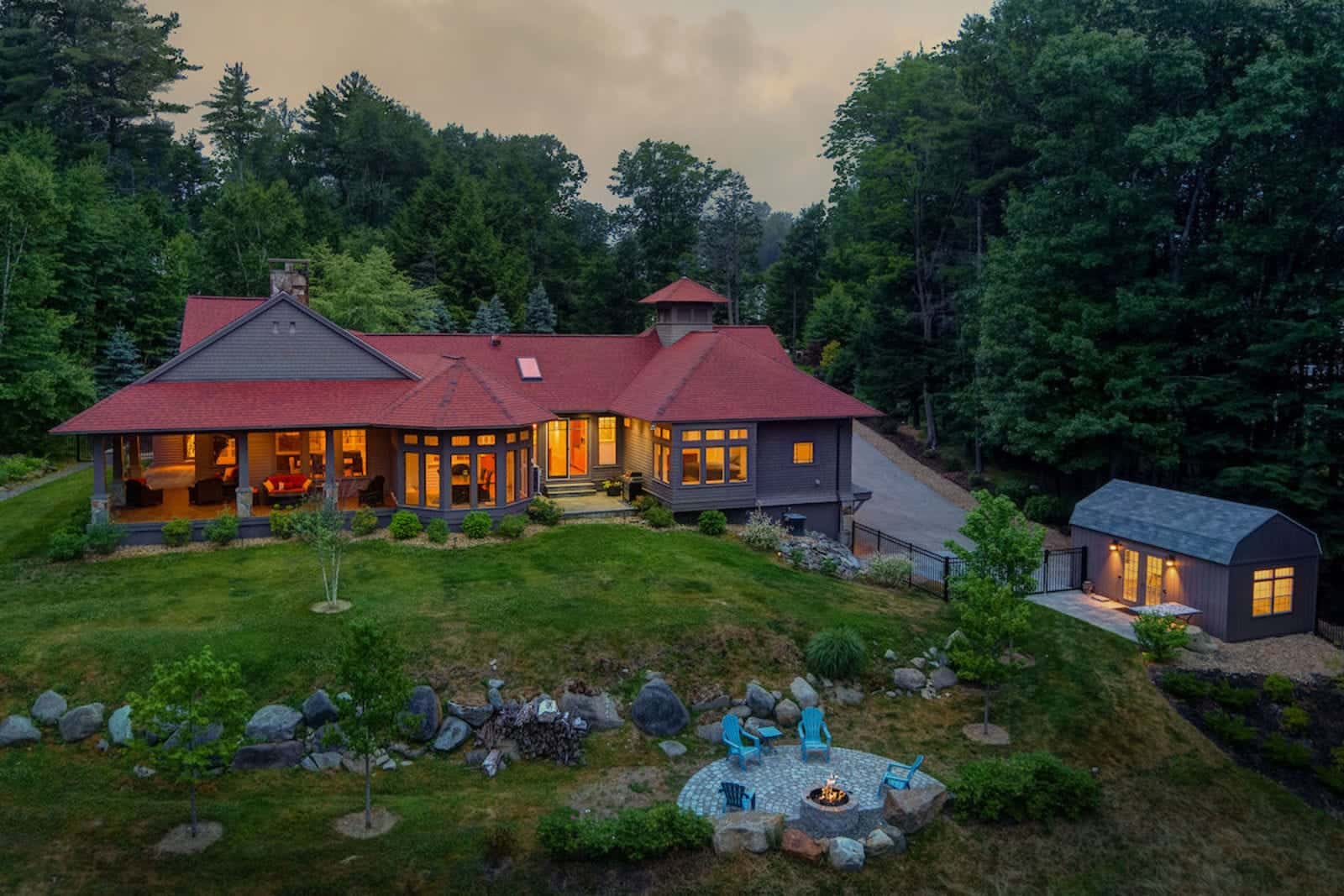 Twilight exterior photo of a home in Greenland, New Hampshire, windows glowing at dusk