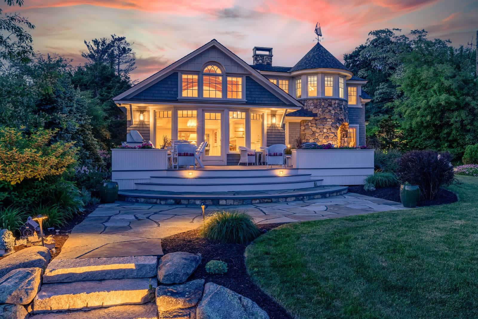 Twilight exterior photo of a home in North Hampton, New Hampshire, windows glowing at dusk