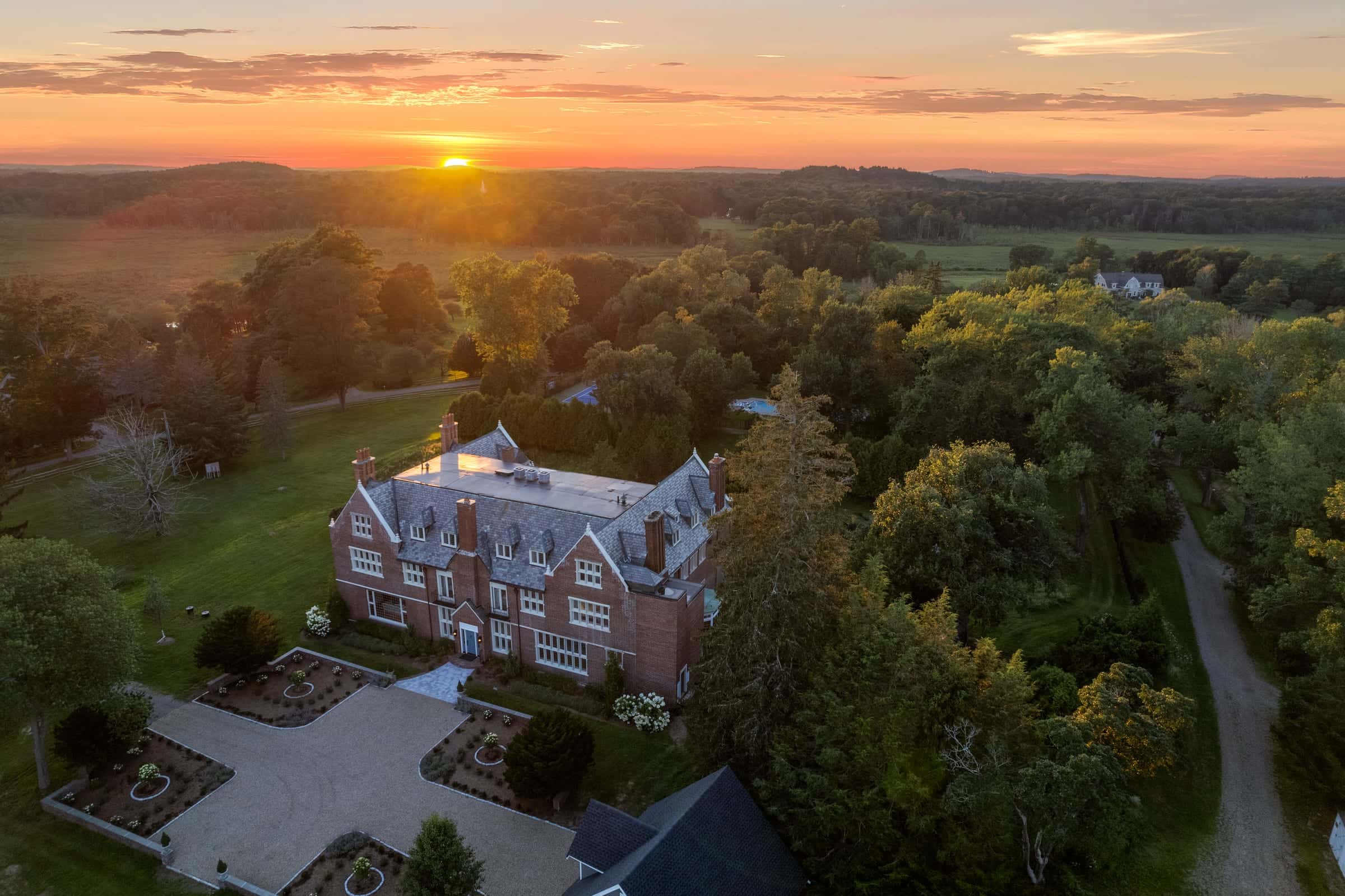 Aerial twilight photo of a brick estate at sunset in Hamilton, Massachusetts