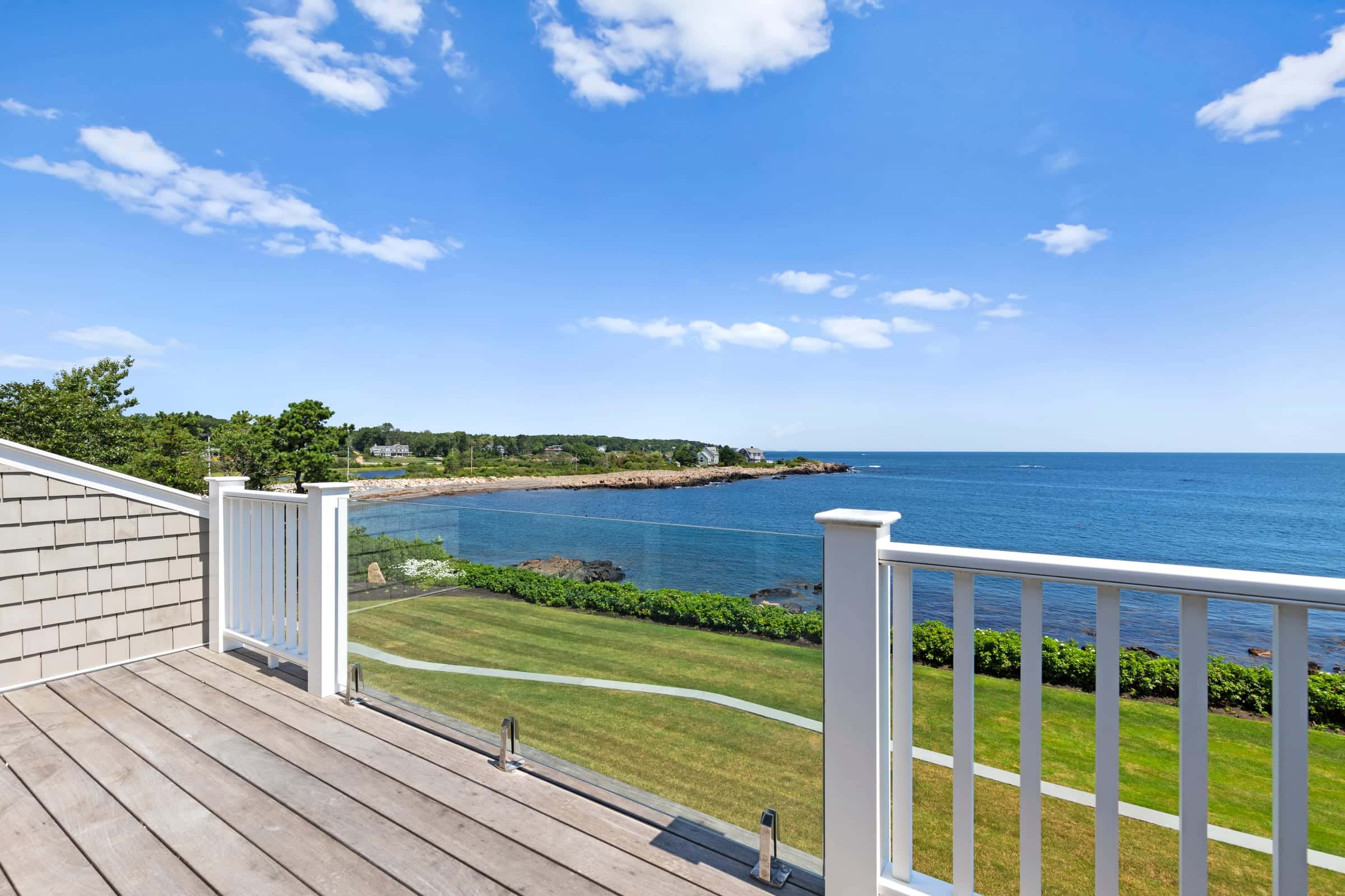 View over a glass-railed deck to a rocky Atlantic cove in York, Maine